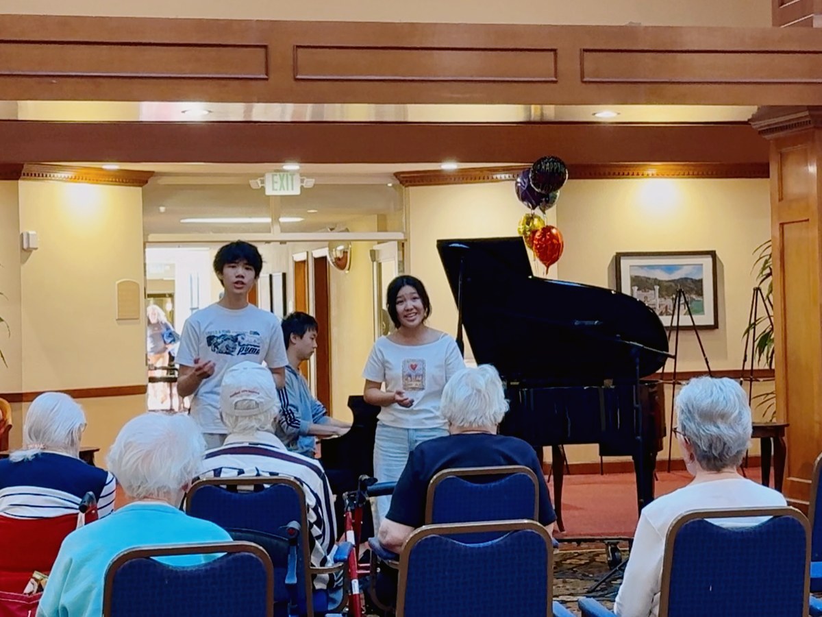 Young artists performing for a senior community audience.