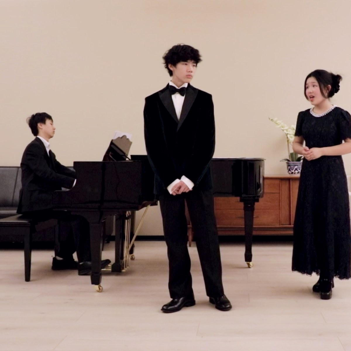 Young performers sharing music beside a piano.