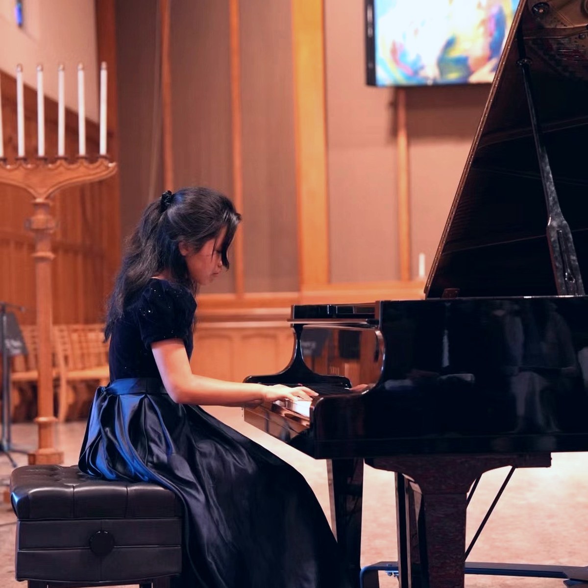 A young pianist performing on stage.