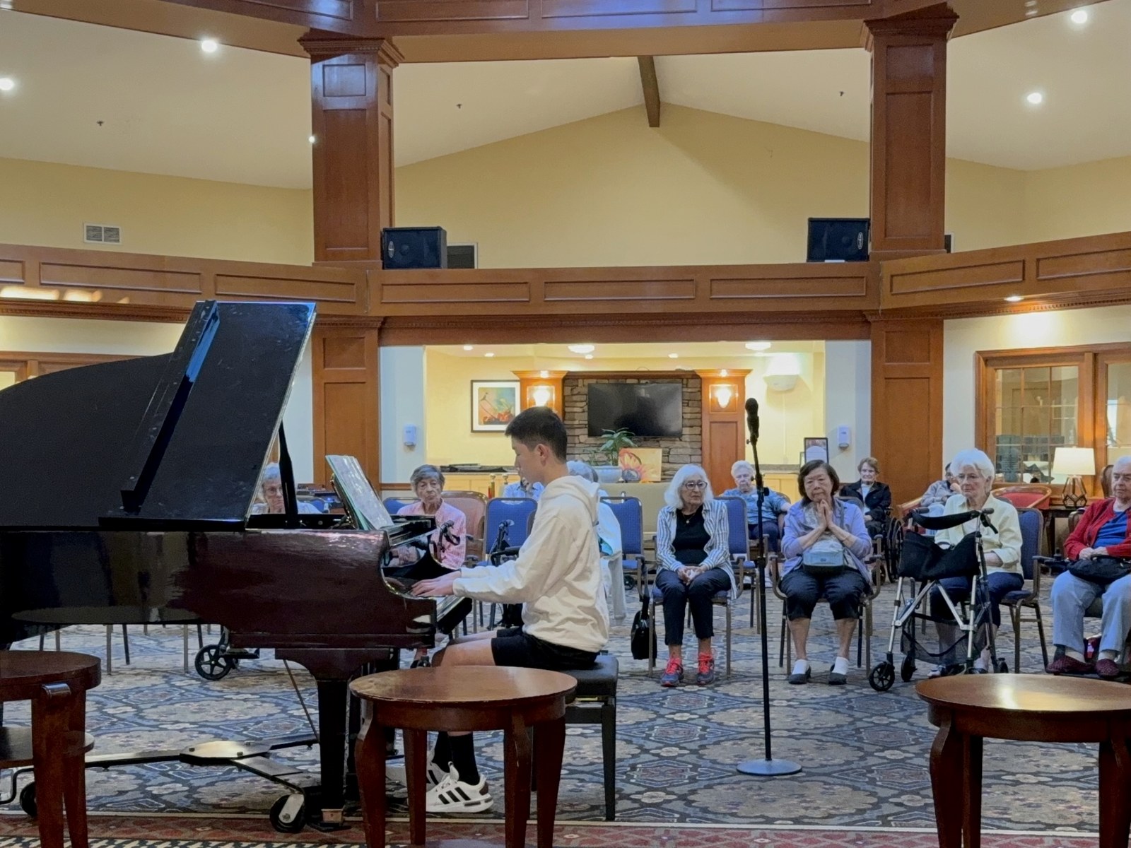A student pianist performing for residents at a senior community.