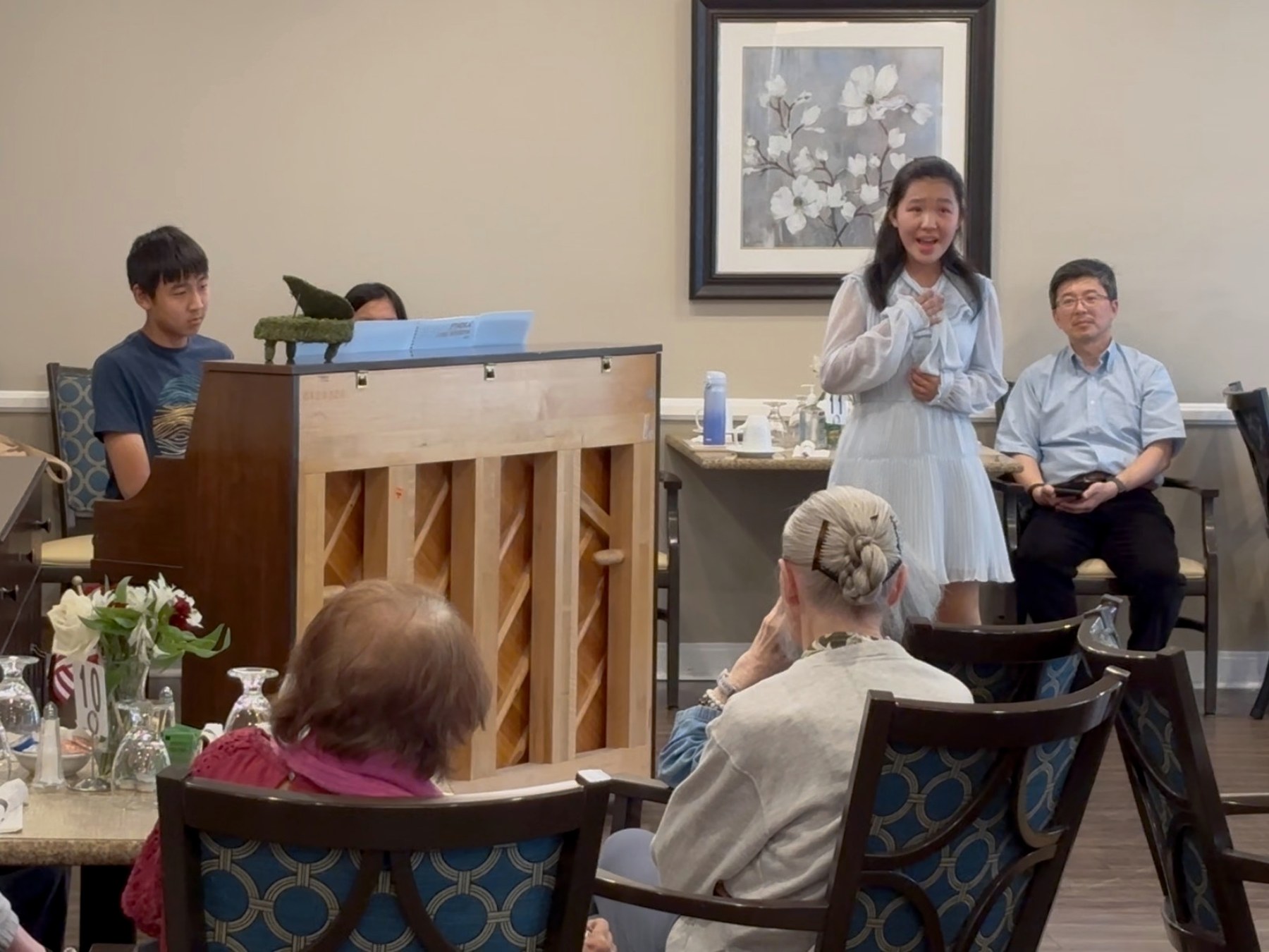 Students sharing voice and piano with a senior community audience.