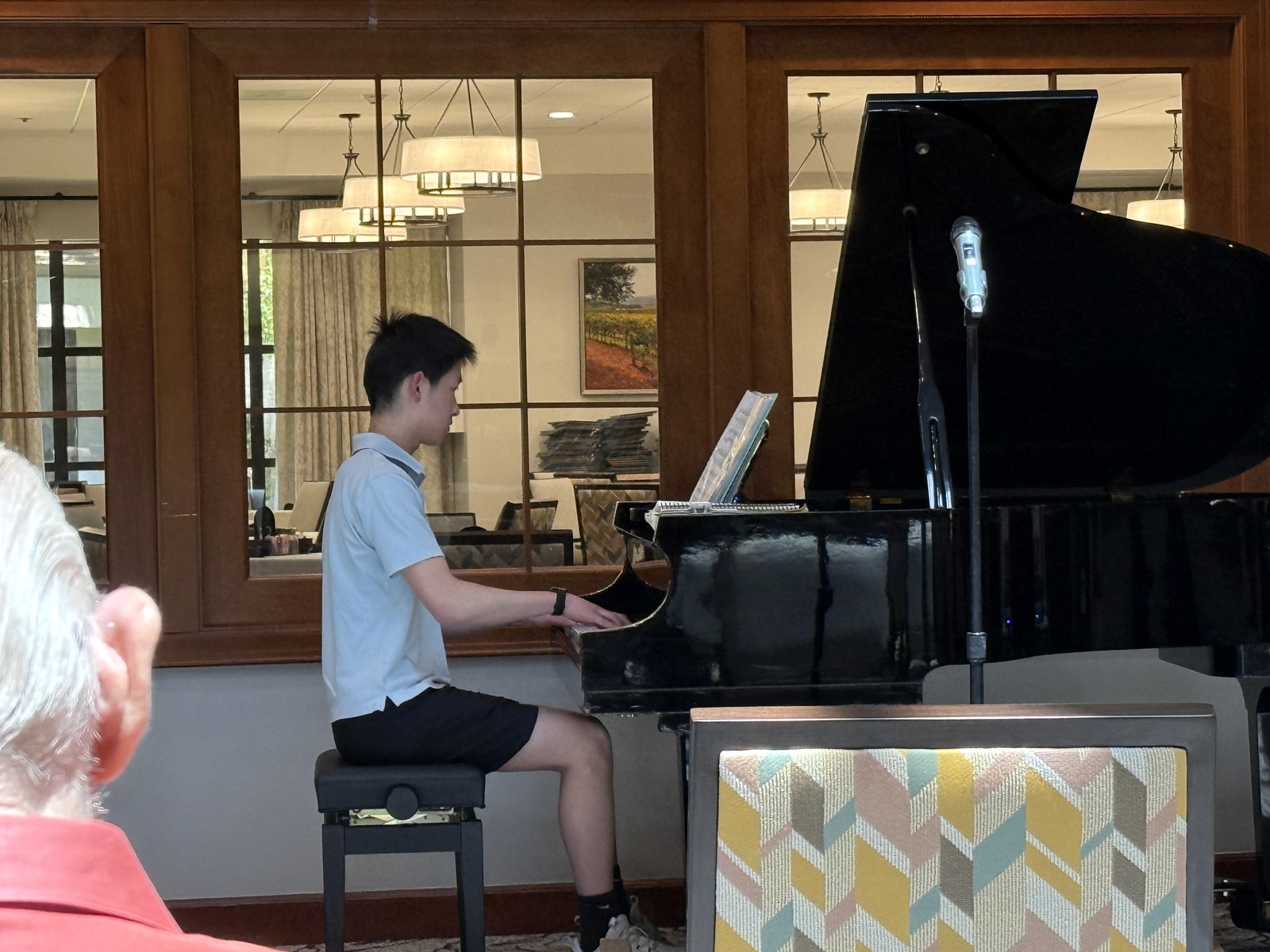 A student performing piano for senior residents.