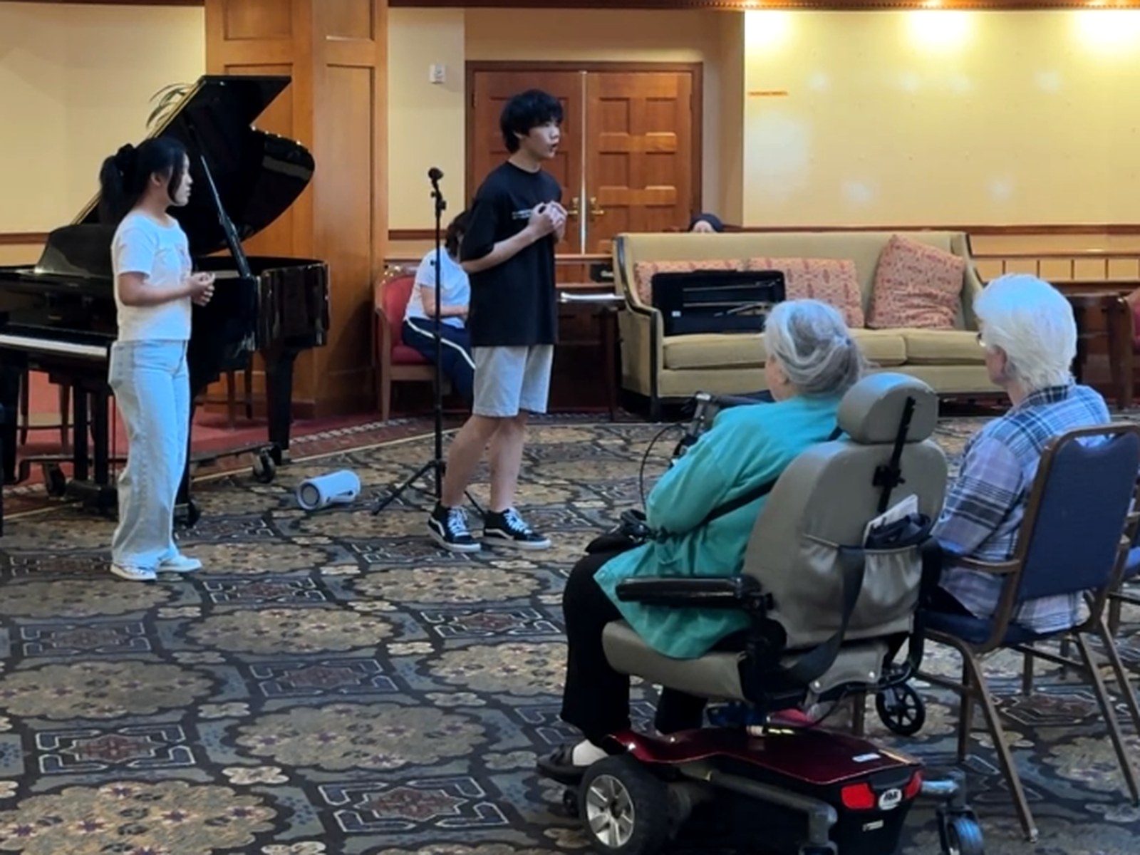 Students performing for a small group of senior community residents.