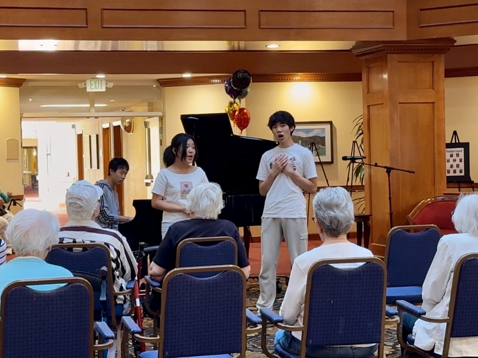 Young vocalists performing for a seated audience.