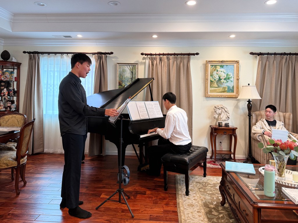A vocalist and pianist working through music during rehearsal.