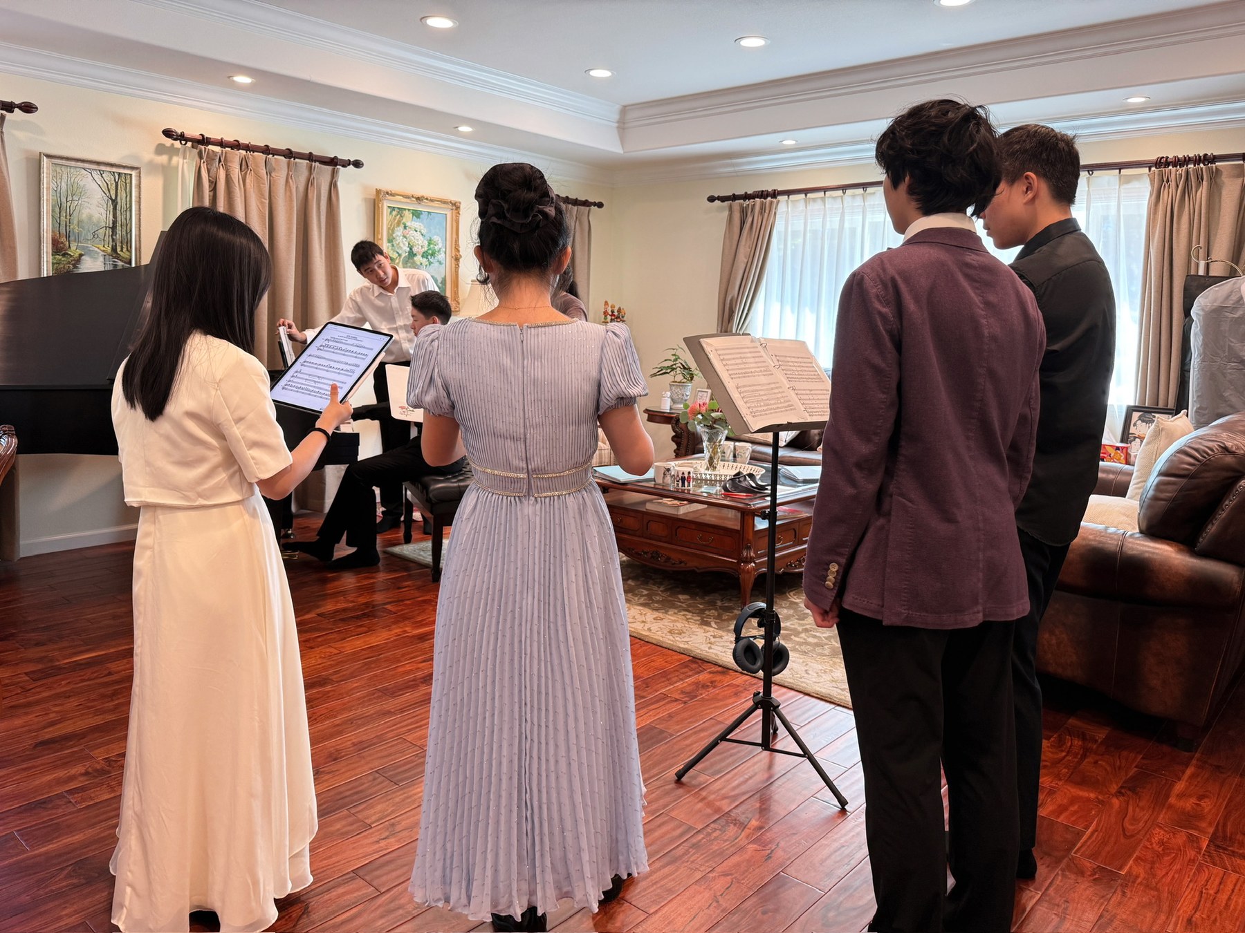 The ensemble rehearsing together around the piano.